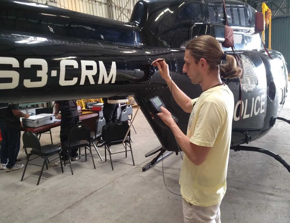 OKOndt Group's specialist is checking the helicopter skin using the portable eddy current flaw detector Eddycon C